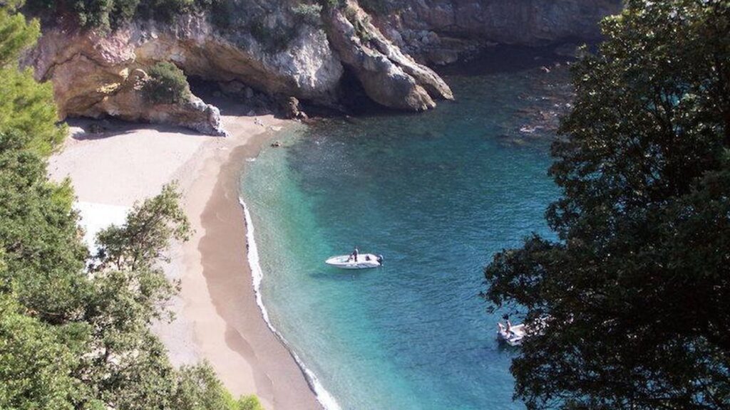 Piccola spiaggia libera in una baia della Liguria con acqua turchese
