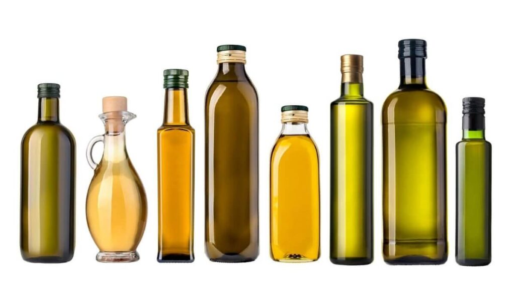 Bottiglia di olio extravergine d'oliva con olive sullo sfondo