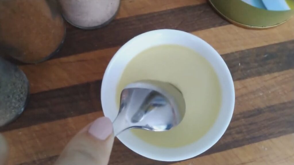 Ristoratore versa olio d'oliva dalla bottiglia in una ciotola
