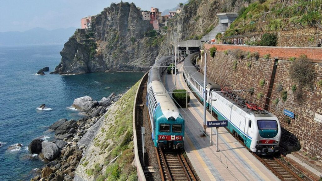 Treno Trenitalia lungo la costa italiana con mare sullo sfondo